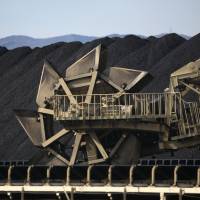 A bucket wheel reclaimer operates at a coal storage lot in the port of Onahama in Iwaki, Fukushima Prefecture, in February 2014. | BLOOMBERG