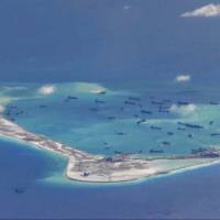 Chinese dredging vessels are purportedly seen in waters around Mischief Reef in the disputed Spratly Islands in the South China Sea, in this still image from video taken by a P-8A Poseidon surveillance aircraft and obtained May 21. | U.S. NAVY / REUTERS