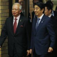 Malaysian Prime Minister Najib Razak and Prime Minister Shinzo Abe arrive for a formal dinner at the Prime Minister\'s Official Residence in Tokyo on Monday. | AP