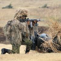 A Ground Self-Defense Force soldier takes aim during a drill in Narashino, Chiba Prefecture, in January 2014. The public is uneasy about the wording of two security bills that would allow Japan\'s troops to use force abroad for the first time since the war. | AFP-JIJI