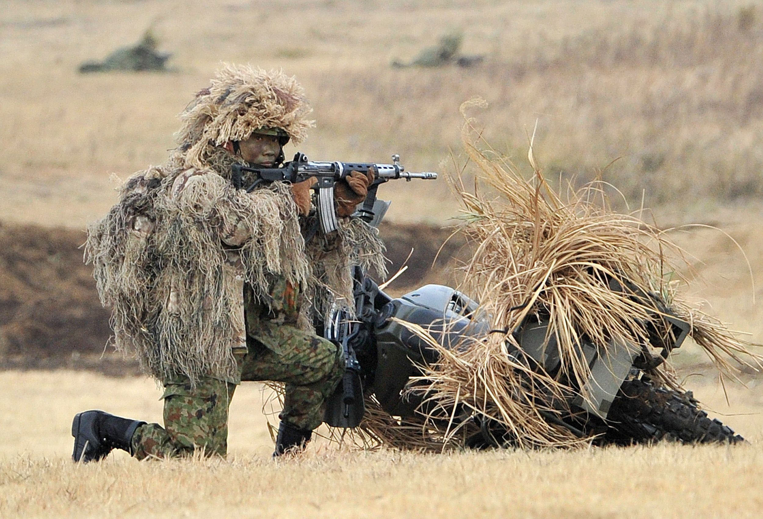 A Ground Self-Defense Force soldier takes aim during a drill in Narashino, Chiba Prefecture, in January 2014. The public is uneasy about the wording of two security bills that would allow Japan's troops to use force abroad for the first time since the war. | AFP-JIJI