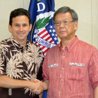 U.S. Sen. Brian Schatz greets visiting Okinawa Gov. Takeshi Onaga in Honolulu on Thursday. During their talks, the Hawaii Democrat vowed to support Okinawa’s resistance to the planned relocation of U.S. Marine Corps Air Station Futenma within the prefecture. | KYODO