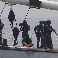 Members of the Philippine coast guard’s anti-terrorist unit apprehend mock pirates who hijacked a vessel during a combined maritime law enforcement exercise at a bay in Manila Wednesday. Philippine and Japanese coast guard teams staged an anti-piracy drill on the same day, featuring the storming of a cargo vessel after a mock hijack, in a show of maritime cooperation between the two nations amid rising tension in Asian waters. Philippine, Japanese coast guards hold anti-piracy drills