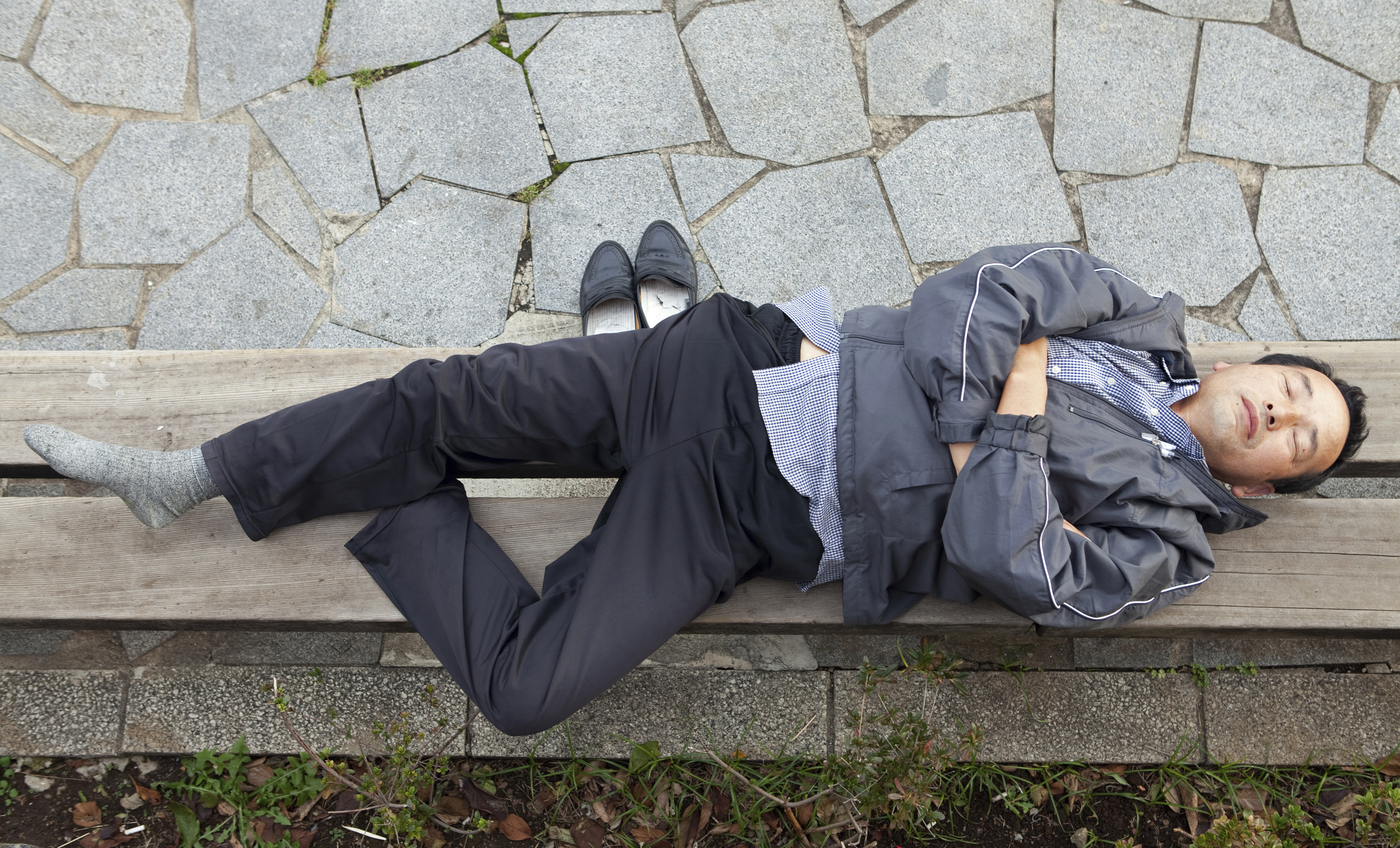 A man sleeps on a bench in Tokyo in November 2010. | ISTOCK