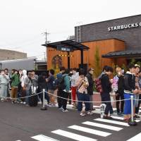 People wait for a Starbucks outlet to open Saturday in Tottori, the last prefecture in the nation to become part of the coffee giant\'s network. | KYODO