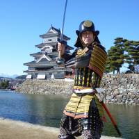 Chris Glenn poses in traditional battle armor he handcrafted, in front of Matsumoto Castle in Nagano Prefecture. | COURTESY OF CHRIS GLENN