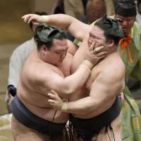 Arm tussle: Kisenosato (left) vies for a victory against Goeido on Tuesday in the Summer Grand Sumo Tournament. With the win, Kisenosato improved to 8-2. | KYODO