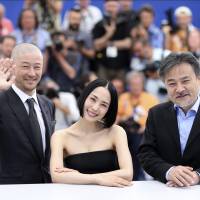 Winning team: Director Kiyoshi Kurosawa poses beside Tadanobu Asano and Eri Fukatsu, the stars of his film \"Kishibe no Tabi\" (\"Journey to the Shore\"), at the 68th Cannes film festival. | AP / THIBAULT CAMUS
