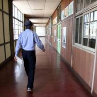 A corrections official walks down a hallway at Tama Juvenile Training School in May. | SATOKO KAWASAKI