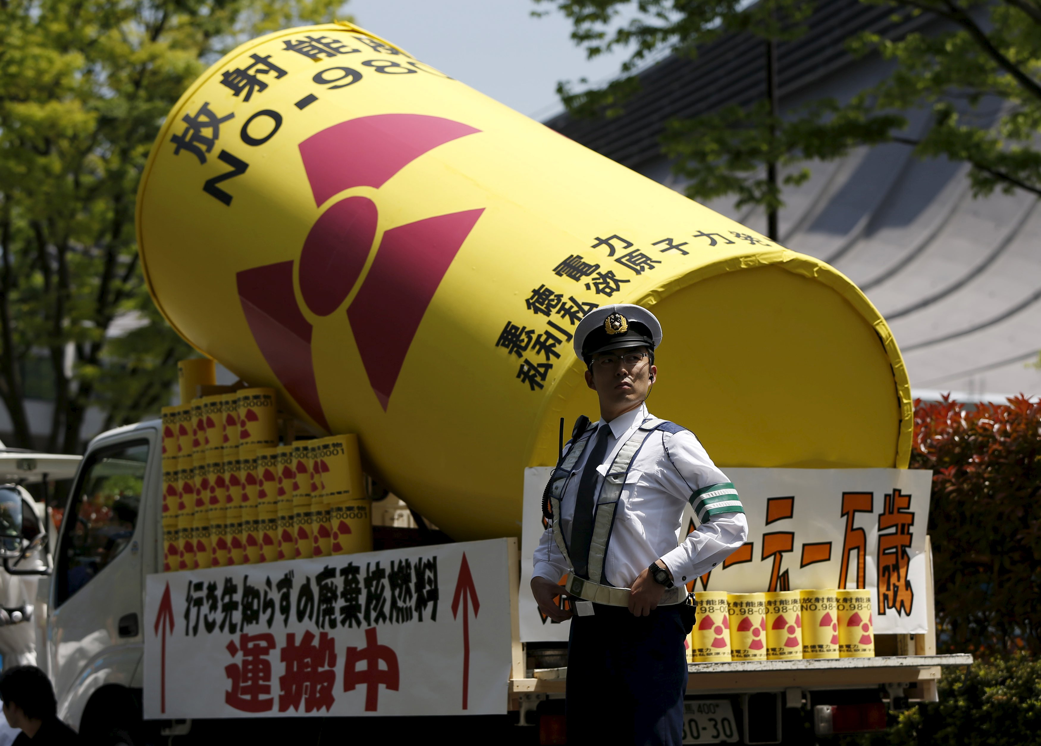 Not having it: A police officer stands guard in front of a protesters' float during this month's annual May Day rally in Tokyo. The government recently declared nuclear power to be the cheapest form of energy for the future, but critics don't agree. | REUTERS