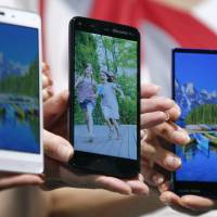 The \"Big Three\": Sharp Corp. unveils phones tied to Japan\'s three main carriers &#8212; NTT Docomo, KDDI and SoftBank &#8212; in November 2013. From this month, users should theoretically be able to \"unlock\" handsets six months after purchasing them and change carrier without having to change their phone. | BLOOMBERG