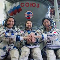 American Kjell Lindgren (left), Russian Oleg Kononenko (center) and Japanese Kimiya Yui pose at a training session in Star City, near Moscow, on Thursday. They are scheduled to blast off for the International Space Station at the end of May. | AFP-JIJI