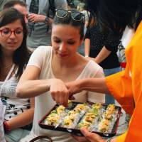 A woman tries out sushi with fugu on Sunday at the Japan Pavilion of Expo Milano 2015. Japanese exports of the potentially toxic fish became available for the first time in the European Union after special permission was granted for the expo. Imports of fugu are strictly prohibited in the EU. | KYODO