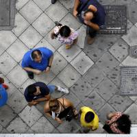 People line up to withdraw cash from an ATM outside a Eurobank branch in Athens on Sunday. | REUTERS
