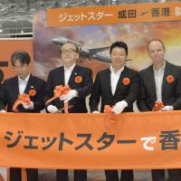 Jetstar Japan chief Masaru Kataoka (center) and other executives attend a ribbon-cutting ceremony to mark the launch of the low-cost carrier\'s Narita-Hong Kong route Monday at Narita International Airport in Chiba Prefecture. | KYODO