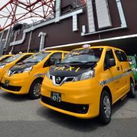 Nissan Motor\'s new NV200 taxis are lined up below Tokyo Tower in Minato Ward prior to a launching ceremony Monday. | AFP-JIJI