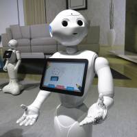 A Pepper robot shows off a photo journal entry it \"wrote\" during a demonstration Thursday, when SoftBank Corp. announced that the humanoid robots will go on sale to the general public this weekend. | KAZUAKI NAGATA