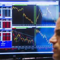 A trader works the floor of the New York Stock Exchange shortly before the closing bell Monday, when stocks fell sharply in heavy trading. | REUTERS