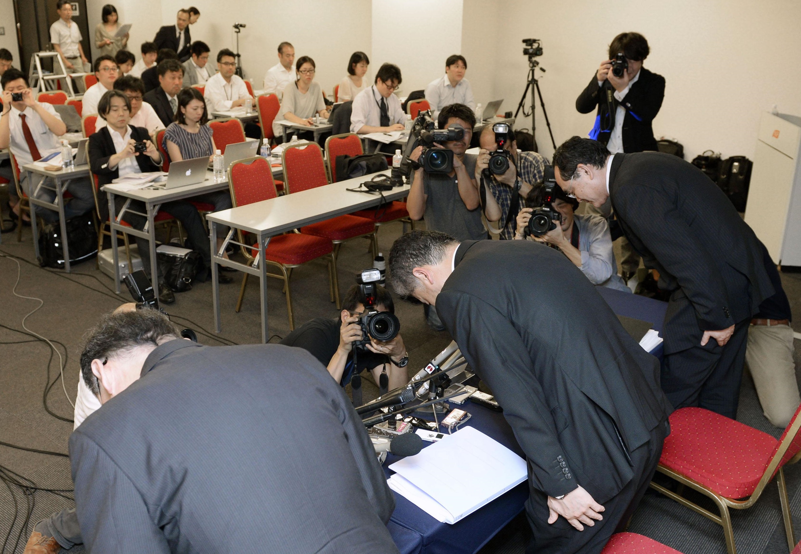 Toyo Tire &amp; Rubber Co. President Takuji Yamamoto (center) bows Tuesday with other executives after a news conference in Osaka. | KYODO