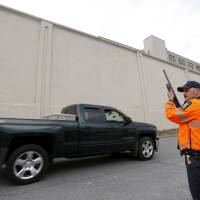 A New York State Correctional Services officer stands guard outside the Clinton Correctional Facility in Dannemora, New York, Monday. Two convicted murderers who used power tools to break out of the maximum security prison may have had help, and they left a taunting note for their jailors to \"Have a nice day,\" authorities said on Sunday. Authorities were questioning a female former employee of the prison. | REUTERS