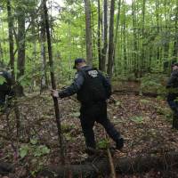 Members of the New York State Department of Corrections and Community Supervision emergency response team search a wooded area for two prisoners who escaped from the Clinton Correctional Facility on Monda in Dannemora, New York. The two murderers who escaped from the prison by cutting through steel walls and pipes remained on the loose Monday as authorities investigate how the inmates obtained the power tools used in the breakout. | AP