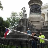 State workers take down a Confederate national flag on the grounds of the state Capitol in Wednesday in Montgomery. Alabama, after Gov. Robert Bentley ordered their removal. | AP