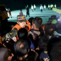 Relatives of passengers of a sunken cruise ship push a cordon of paramilitary police as they march toward the site of the ship in the Jianli section of Yangtze River, Hubei province, China, Wednesday. Dozens of people broke through the police cordon as they marched toward the site of the ship to demand news of missing kin. Kin breach police cordon, head toward Yangtze shipwreck site as survivor hopes fade