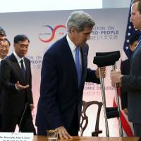 U.S. Secretary of State John Kerry takes a pair of crutches as he leaves after a climate change session during the Strategic and Economic Dialogue (S&ED) at the State Department in Washington June 23, 2015. The United States on Tuesday expressed deep concern about state-sponsored cyber theft and stressed the need to keep Asian sea lanes open at the start of annual talks with China, and said the world depended on the ability of the two countries to narrow their differences. | REUTERS