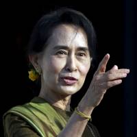 Aung San Suu Kyi arrives at the parliament buildings on the Stormont estate in Belfast in this Oct. 24, 2013, file photo. Chinese leaders will woo Myanmar\'s opposition leader and Nobel laureate on her first visit to the country, a snub for the quasi-military government whose fighting with rebels along China\'s border has angered Beijing. | REUTERS