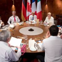 Group of Seven leaders (clockwise, from center) U.S. President Barack Obama, German Chancellor Angela Merkel, French President Francois Hollande, British Prime Minister David Cameron, Italian Prime Minister Matteo Renzi, European Commission President Jean-Claude Juncker, European Council President Donald Tusk, Prime Minister Shinzo Abe and Canadian Prime Minister Stephen Harper attend a working dinner at the G-7 summit at the Elmau Castle near Garmisch-Partenkirchen, southern Germany, Sunday. Obama took the summit opportunity to push Cameron to keep British defense spending from falling below NATO targets. | AFP-JIJI