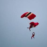 A British army display parachutist tries to snag the tangled lines with his legs. The pair steered into a splashdown at a nearby marina. | @PARA_BAND / TWITTER