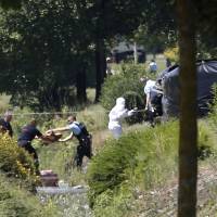 Investigating police officers work outside the gas plant where an attack took place Friday in Saint-Quentin-Fallavier, southeast of Lyon, France. French authorities say one person was beheaded in the attack and explosion. | AP