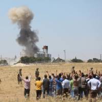 Smoke rises in the Syrian town of Kobani as it is seen from the Turkish border town of Suruc in Sanliurfa province, Turkey, Thursday, when Islamic State fighters launched simultaneous attacks against the Syrian government and Kurdish militia overnight, moving back onto the offensive. | REUTERS