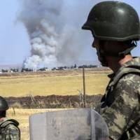 Turkish soldiers stand guard by the border with Syria, on the way to Mursitpinar crossing gate in Suruc, Sanliurfa province, on Thursday. Turkey denied \"baseless\" claims that Islamic State  militants reentered the Syrian town of Kobani through the border crossing to detonate a suicide bomb. | AFP-JIJI