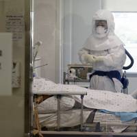 A health care worker wearing protective gear as a precaution against the MERS virus tends to a MERS patient inside an isolation ward at Seoul Medical Center on Wednesday. South Korea believes its MERS outbreak may have peaked, and experts say the next several days will be critical to determining whether the government\'s belated efforts have successfully stymied a disease that has killed seven people and infected 120 in the country. | YUN DONG-JIN / YONHAP VIA AP
