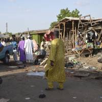 People gather at the site of a suicide bomb attack at a market in Maiduguri, Nigeria, Monday. Two girls blew themselves up on Monday near a crowded mosque in northeast Nigeria\'s biggest city, killing about 30 people, witnesses said. It is the fourth suicide bombing this month in Maiduguri, which is the birthplace of the Boko Haram Islamic extremist group. | AP