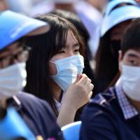 South Korean students wearing face masks attend a Korean Memorial Day ceremony at the National Cemetery in Seoul on Saturday. | AFP-JIJI