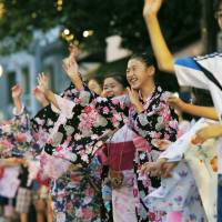 Children dance during the Tsukudajima Bon festival in Tokyo\'s Chuo Ward last July. | KYODO