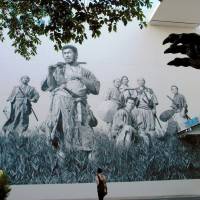 Toshiro Mifune (front) in Akira Kurosawa\'s \"Seven Samurai\" is depicted in this design painted on the front to Toho Studio. The claw of a Godzilla statue can be seen at the right. Both classic movies were released in 1954. | KYODO