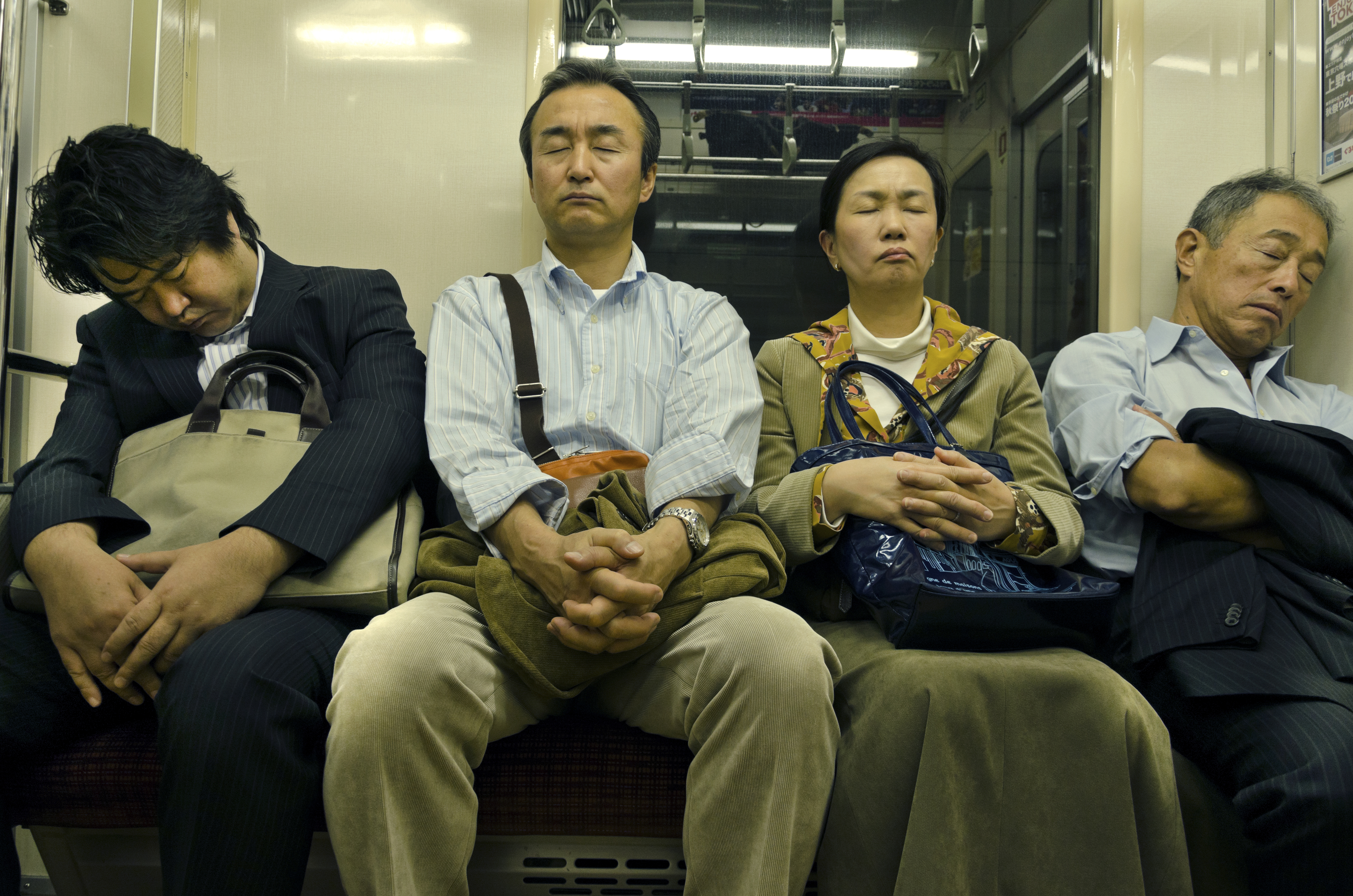 Passengers doze on a Tokyo subway train in October 2012. | ISTOCK