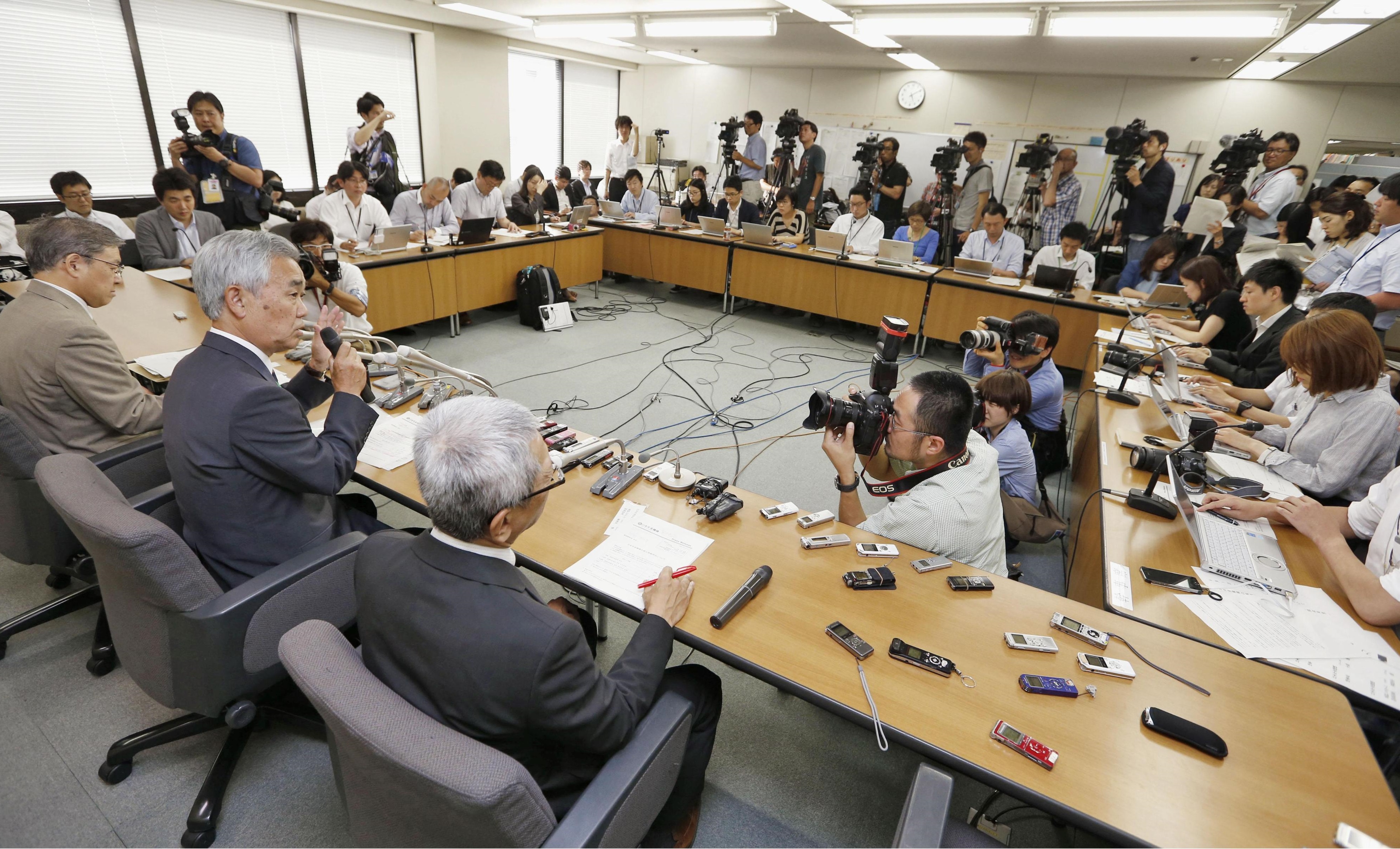 Japan Pension Service President Toichiro Mizushima (center) speaks during a news conference Monday at the health ministry. | KYODO