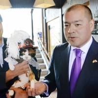 Michael Shearer (right), British consul general in Osaka, meets Tama, the late cat stationmaster of Wakayama Electric Railway\'s Kishi Station in Kinokawa, Wakayama Prefecture, last September. | KYODO