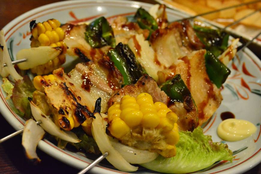 Isaribi Messy feast: One of the signature dishes at Isaribi is skewers loaded with corn, bacon and chicken. | J.J. O'DONOGHUE