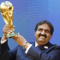 Emir of Qatar Sheikh Hamad bin Kalifa Al-Thani holds the World Cup trophy after being awarded hosting rights for the 2022 tournament in Zurich in December 2010. | AP