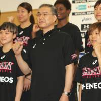 Japan women\'s national basketball team head coach Tomohide Utsumi (center) and his players pose for a photo before opening their training camp at the National Training Center on Wednesday. | KAZ NAGATSUKA