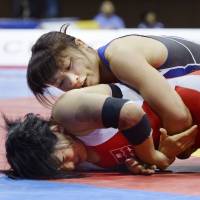Kaori Icho (top) wrestles on her way to victory in the 58-kg class at the national invitational championships on Sunday. | KYODO