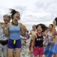 Children play in the sea Friday after participating in a ceremony to kick off the summer at Zushi Beach in Kanagawa Prefecture. | KYODO