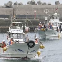 Fishing boats bring back evacuated residents to Yakushima Island after they made a brief return to Kuchinoerabu Island on Monday. | KYODO