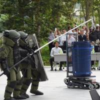 A bomb squad from the Metropolitan Police Department takes part in a counterterrorism drill Tuesday at the Toranomon Hills complex in Minato Ward, Tokyo &#8212; the first such drill carried out at the complex. | SATOKO KAWASAKI