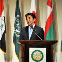 Prime Minister Shinzo Abe speaks while the representative of the Permanent General Mission of Palestine and dean of the Arab diplomatic corps, Waleed Siam, looks on during an Arab Week reception and in celebration of Arab-Japan friendship at the Mandarin Oriental hotel in Tokyo on April 6. | YOSHIAKI MIURA